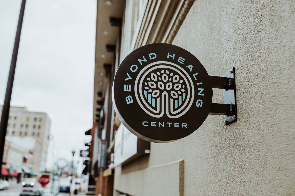 The round Beyond Healing Center sign hanging outside the building in downtown Springfield