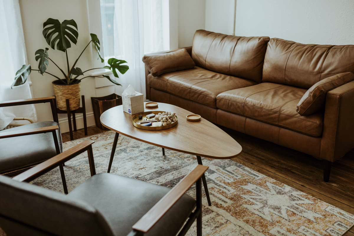 A sofa and plants in a sunlit Beyond Healing counseling office